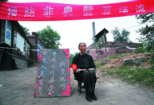 62.“非典”期间，一个老太太在村口执勤.jpg