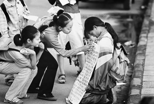 67.两个女孩在端详乞讨者胸前所写内容.jpg