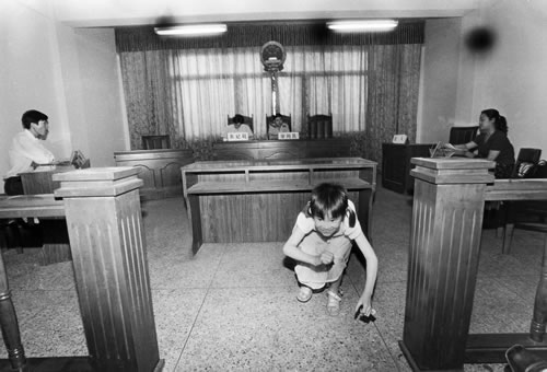 83.父母在法庭上兴讼离婚，孩子在一旁玩耍.jpg