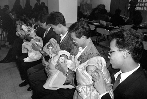 93.初为人父的小伙子学习为婴儿喂奶.jpg